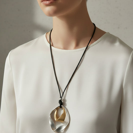 Two necklaces with unique pendants on a textured surface.