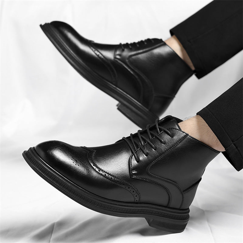 Men's premium black leather wingtip brogue ankle boot standing on an elegant concrete pillar inside a minimalist luxury studio backdrop.