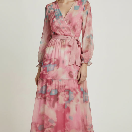 Woman wearing a pink floral dress holding a clutch against a gray background