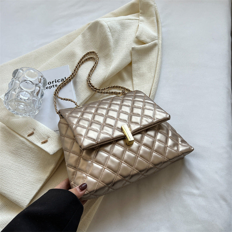 Cream quilted leather messenger bag with a gold chain strap.
