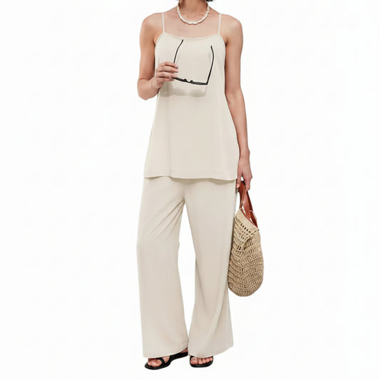 Woman in a beige outfit holding a woven bag against a white wall with text.