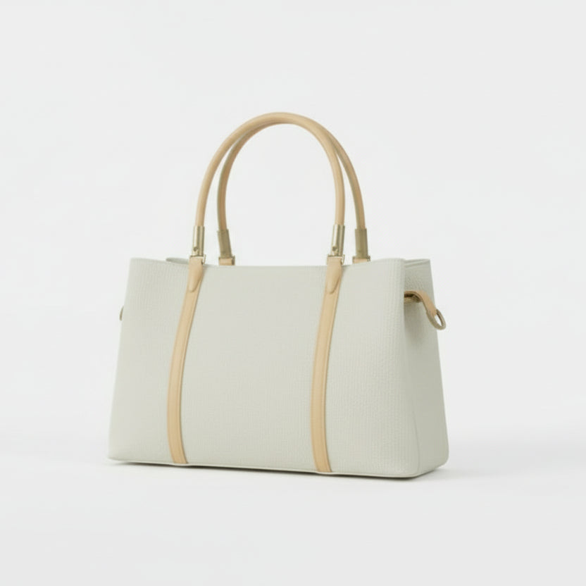 Light green handbag with beige handles on a white surface