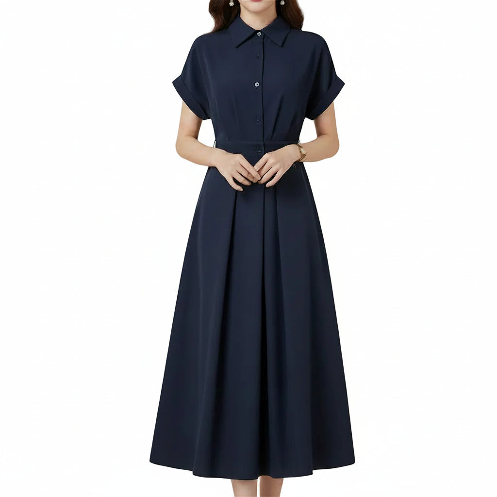 Close-up detail shot of a premium navy blue belted midi dress on a model, showcasing structured waist pleats, a matching fabric belt with a tonal button closure, functional side pockets, and clean studio lighting.
